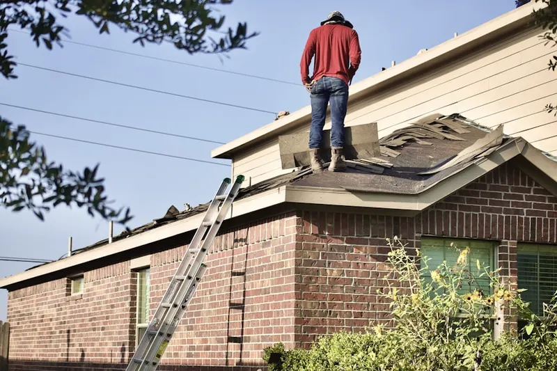 Professional roofer working on a residential roof in Downtown Compton